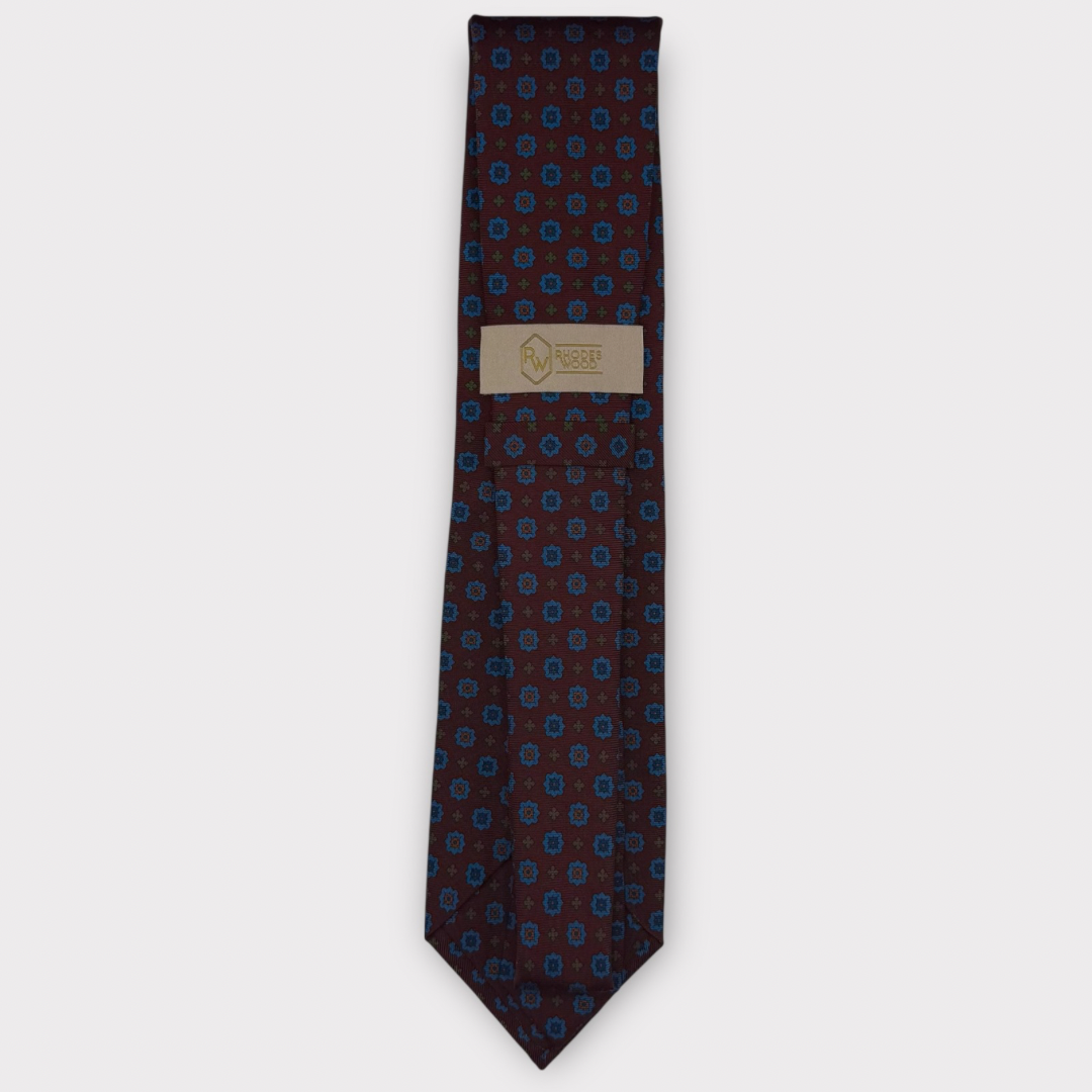 Classic silk necktie, printed in England, with a 9cm blade and 150cm length, laid flat against a plain background