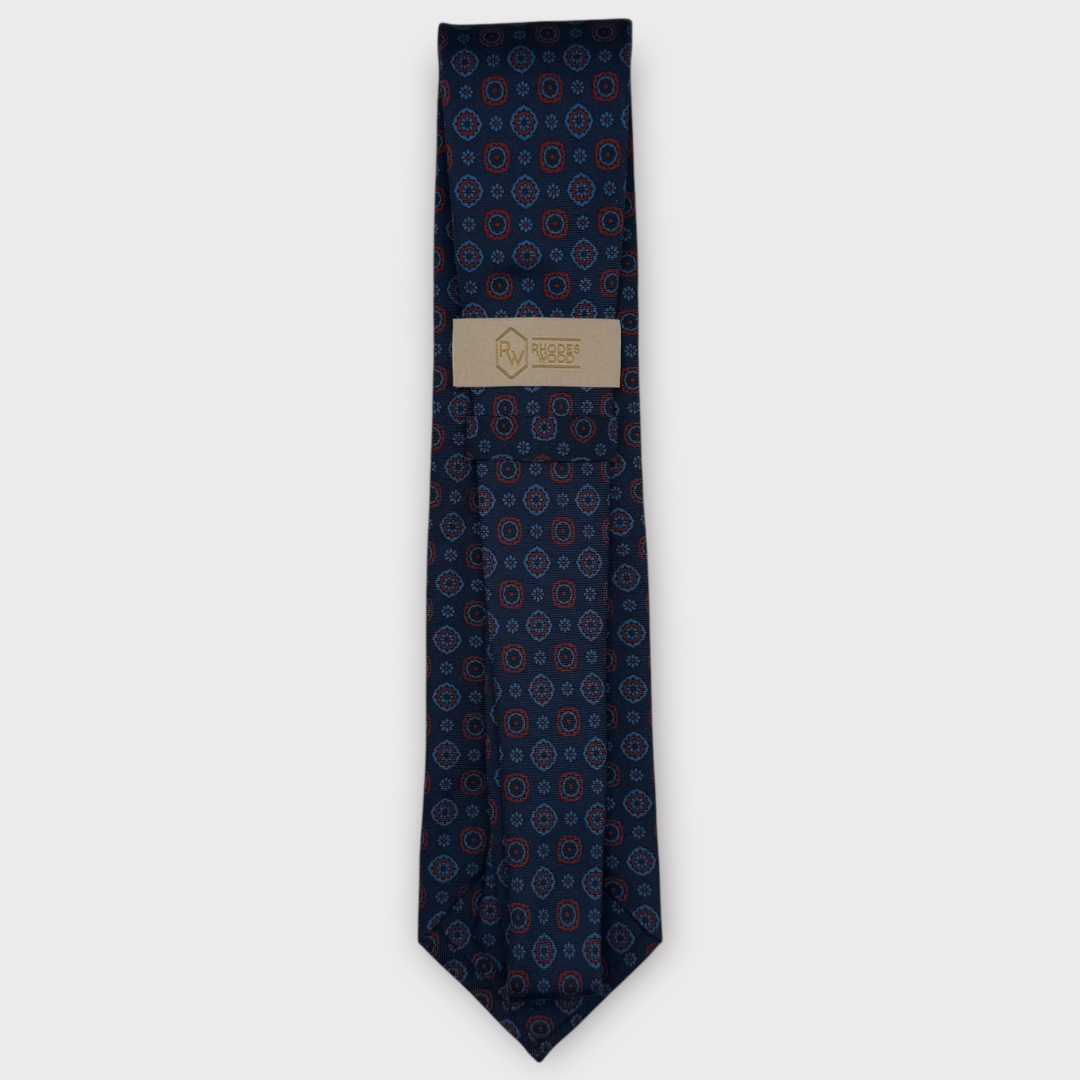Classic silk necktie, printed in England, with a 9cm blade and 150cm length, laid flat against a plain background