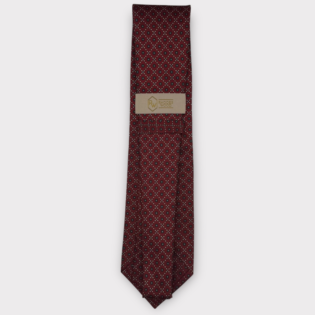 Classic silk necktie, printed in England, with a 9cm blade and 150cm length, laid flat against a plain background
