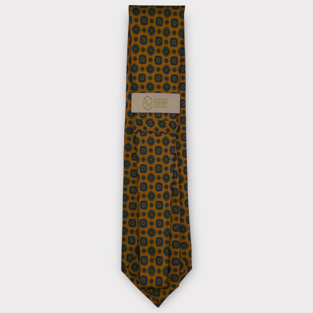 Classic silk necktie, printed in England, with a 9cm blade and 150cm length, laid flat against a plain background