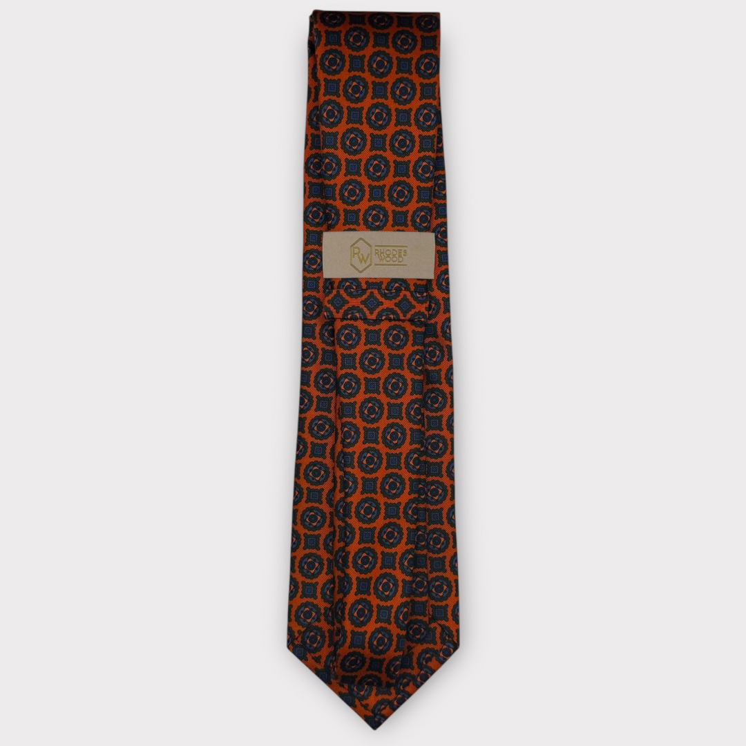 Classic silk necktie, printed in England, with a 9cm blade and 150cm length, laid flat against a plain background
