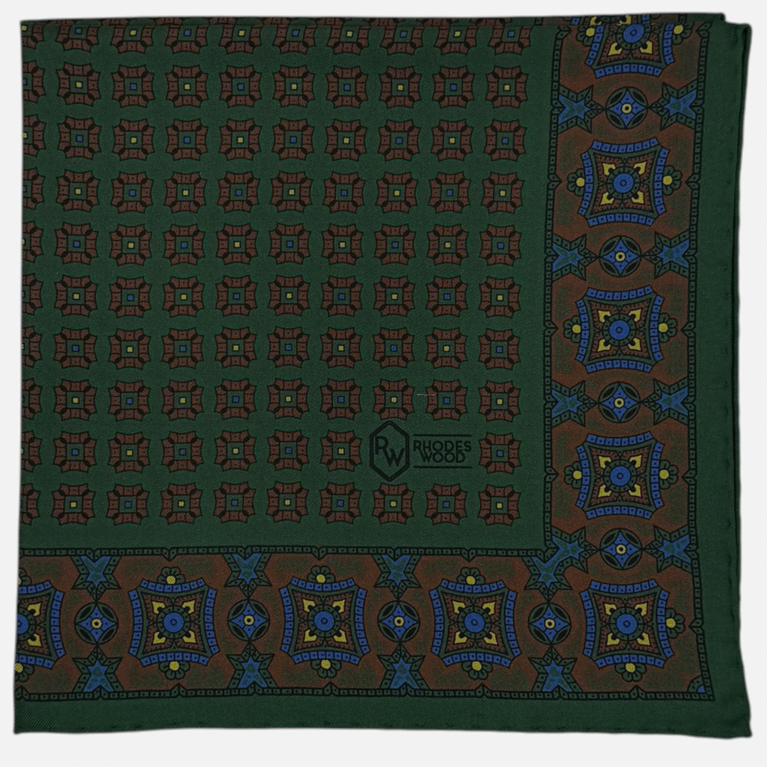 A green pocket square with brown mosaic repeating across the silk.