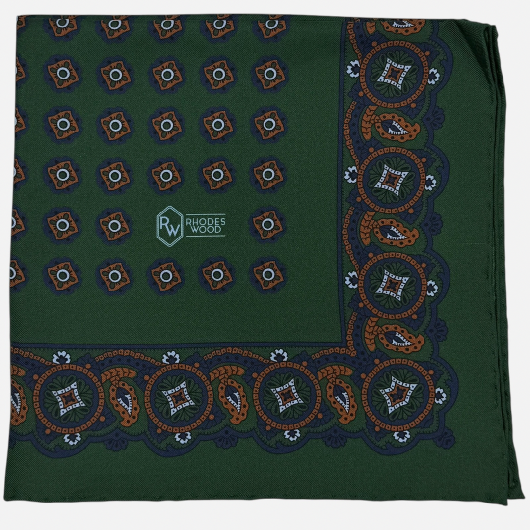 Green pocket square with blue and orange quatrefoils repeating across the silk.