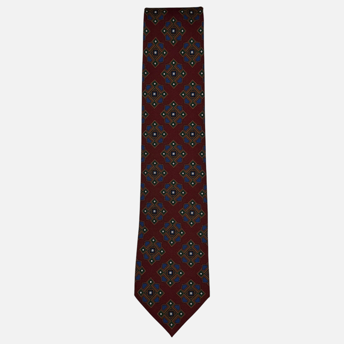 A burgundy neck tie with blue and green large medallions.