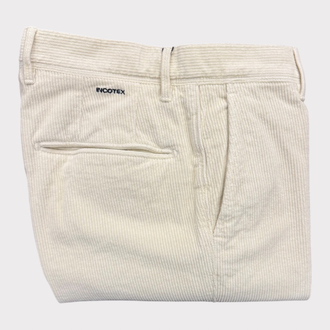 White corduroy pants with 'INCOTEX’ branding on a light gray background