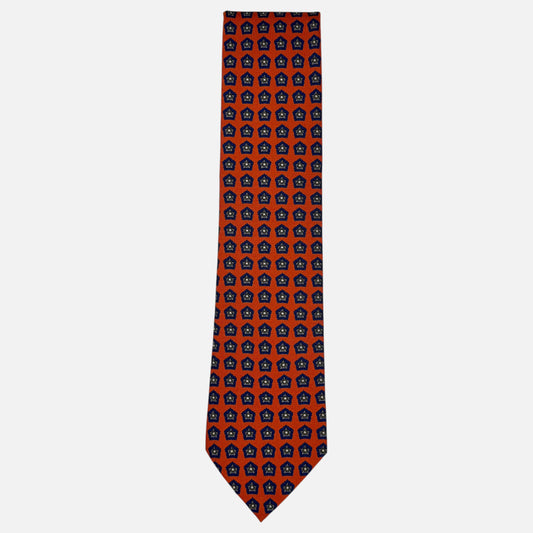 An orange neck tie with blue repeating star medallions. 