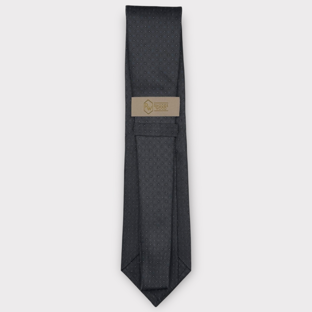 Classic silk necktie, printed in England, with a 9cm blade and 150cm length, laid flat against a plain background