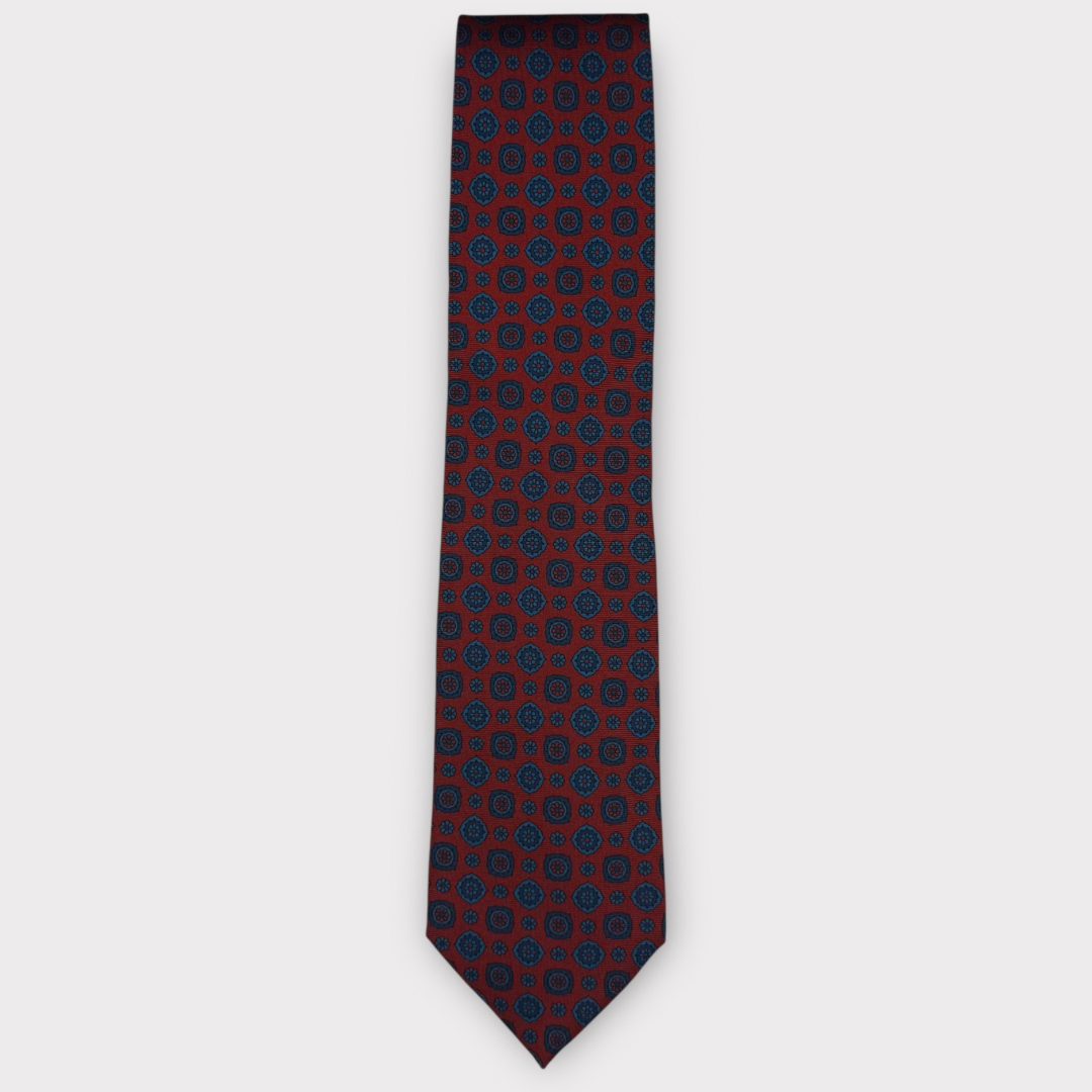 Classic silk necktie, printed in England, with a 9cm blade and 150cm length, laid flat against a plain background