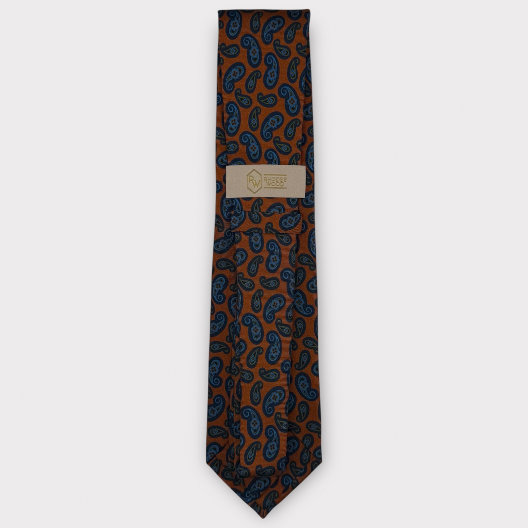 Classic silk necktie, printed in England, with a 9cm blade and 150cm length, laid flat against a plain background