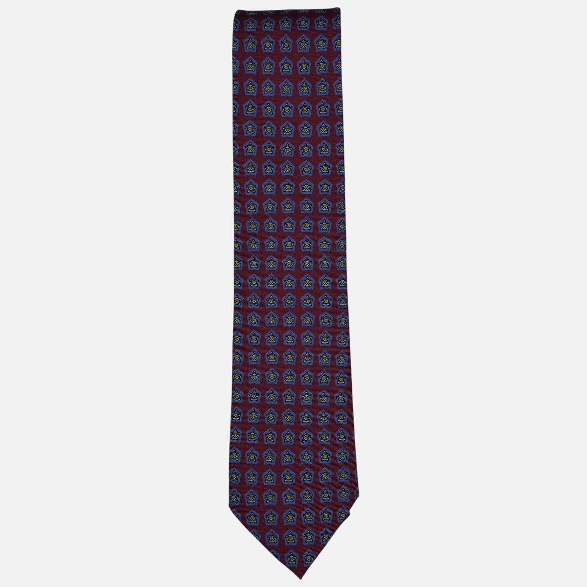 A oxblood neck tie with blue star medallions repeating across the silk.