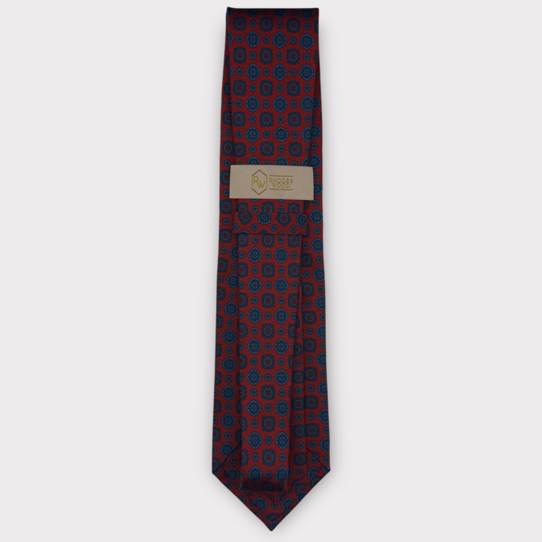 Classic silk necktie, printed in England, with a 9cm blade and 150cm length, laid flat against a plain background