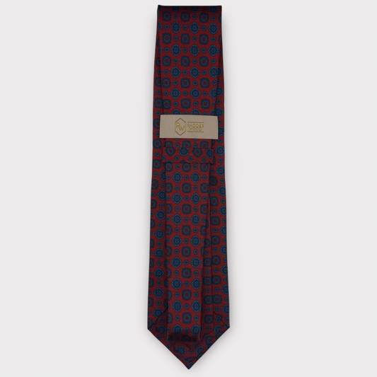 Classic silk necktie, printed in England, with a 9cm blade and 150cm length, laid flat against a plain background