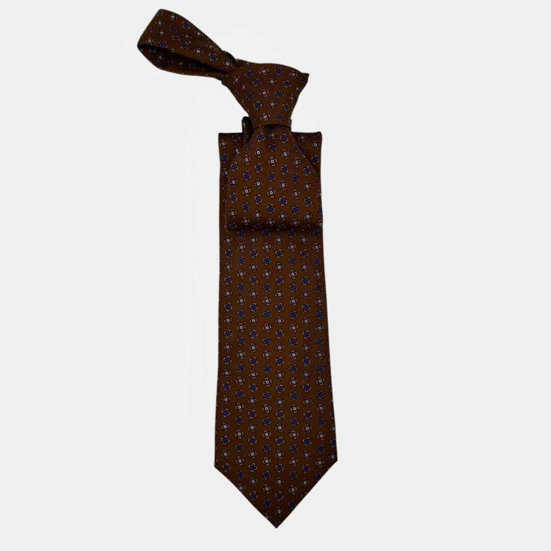 A chestnut coloured tie, with a medallion pattern. 
