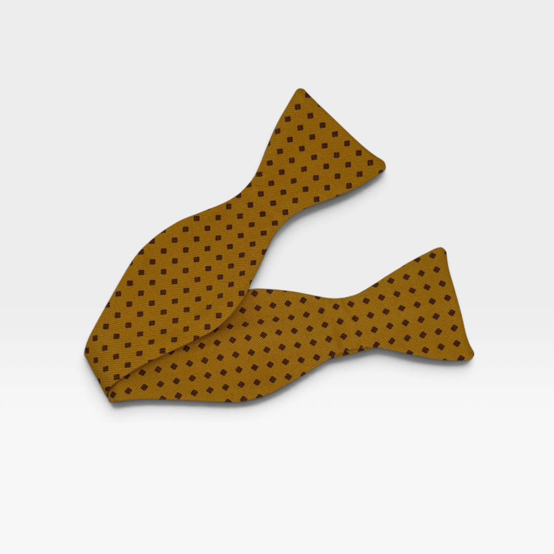 A mustard colour self the bow tie featuring a medallion design 
