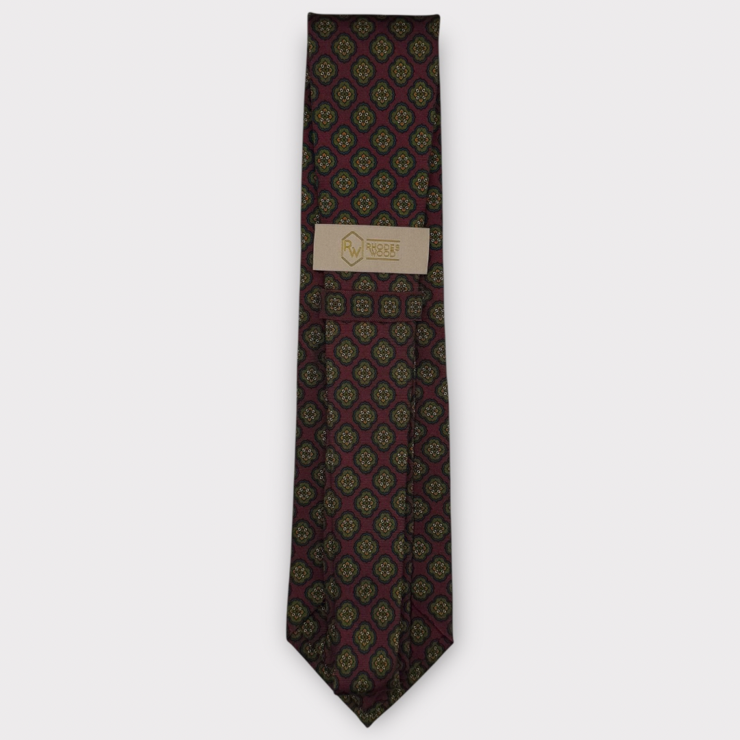 Classic silk necktie, printed in England, with a 9cm blade and 150cm length, laid flat against a plain background