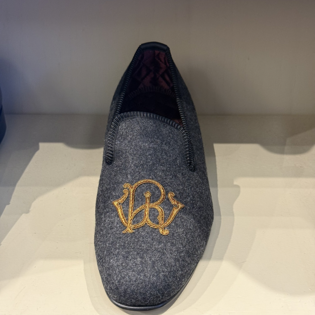 Gray slipper with gold logo on a white background