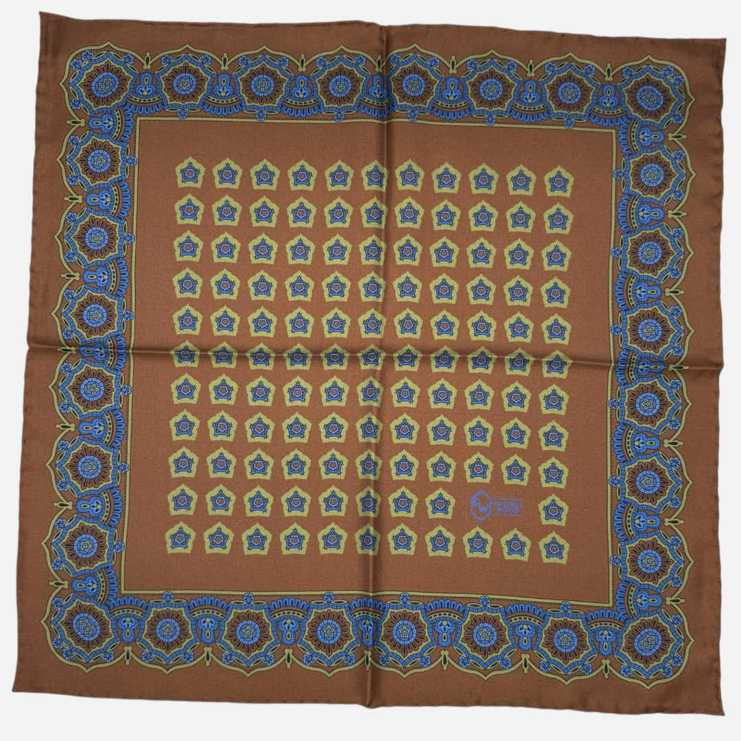 A brown silk pocket squares with light green and blue medallions repeating across the silk 