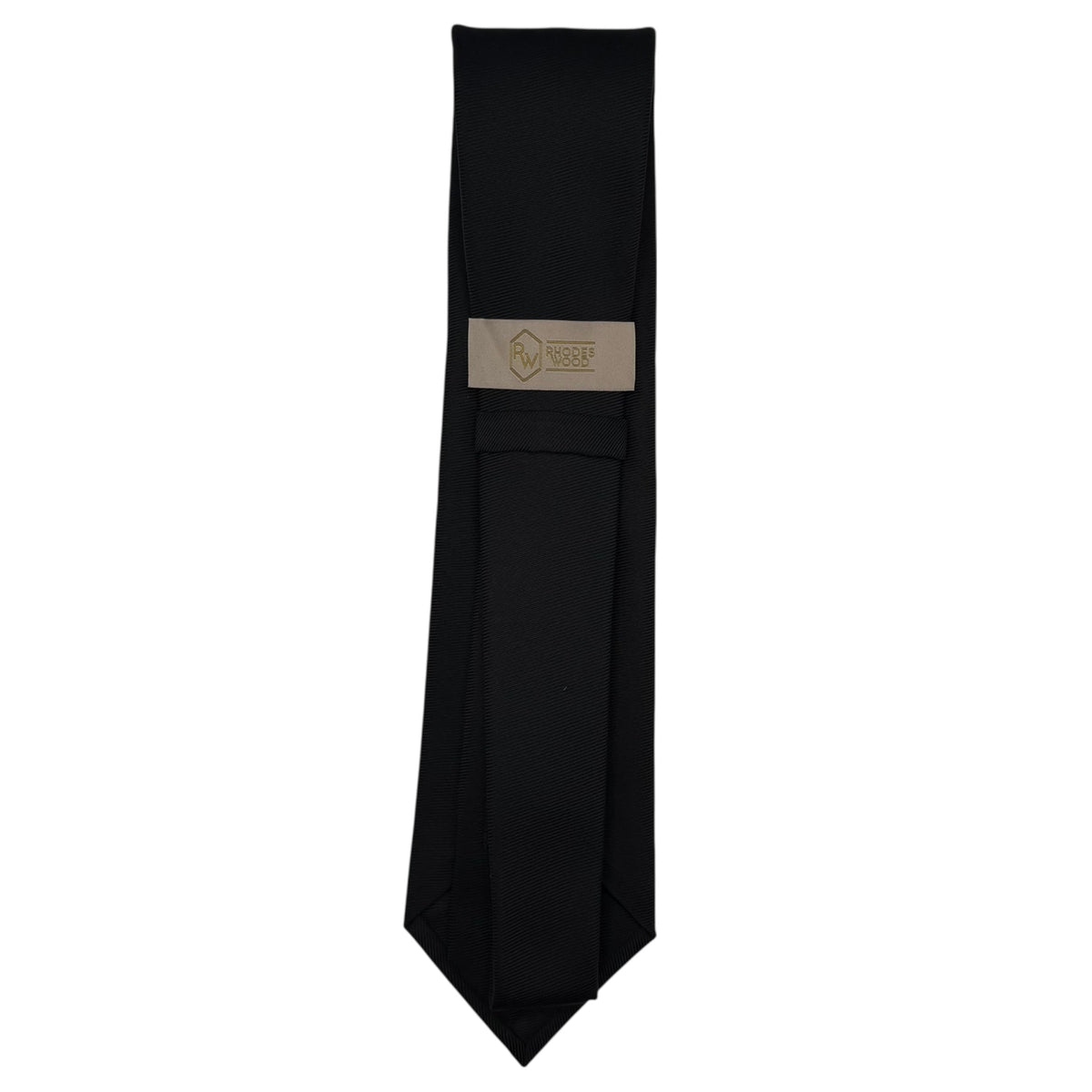 A black necktie with a beige woven label featuring a gold logo, displayed vertically against a plain white background.