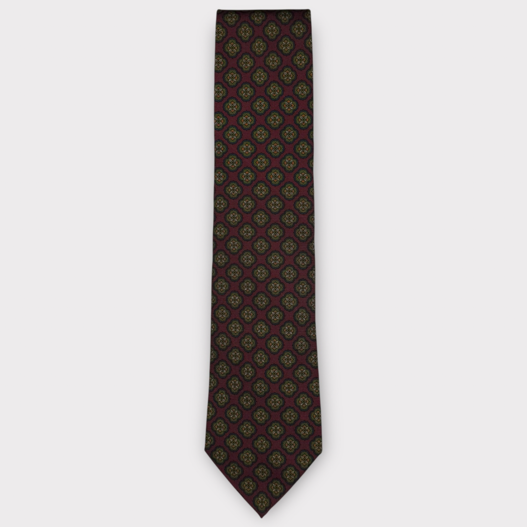 Classic silk necktie, printed in England, with a 9cm blade and 150cm length, laid flat against a plain background