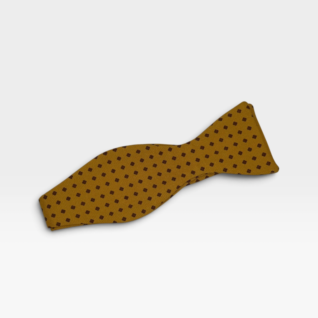 A mustard colour self tie adjustable bow tie featuring a medallion pattern 