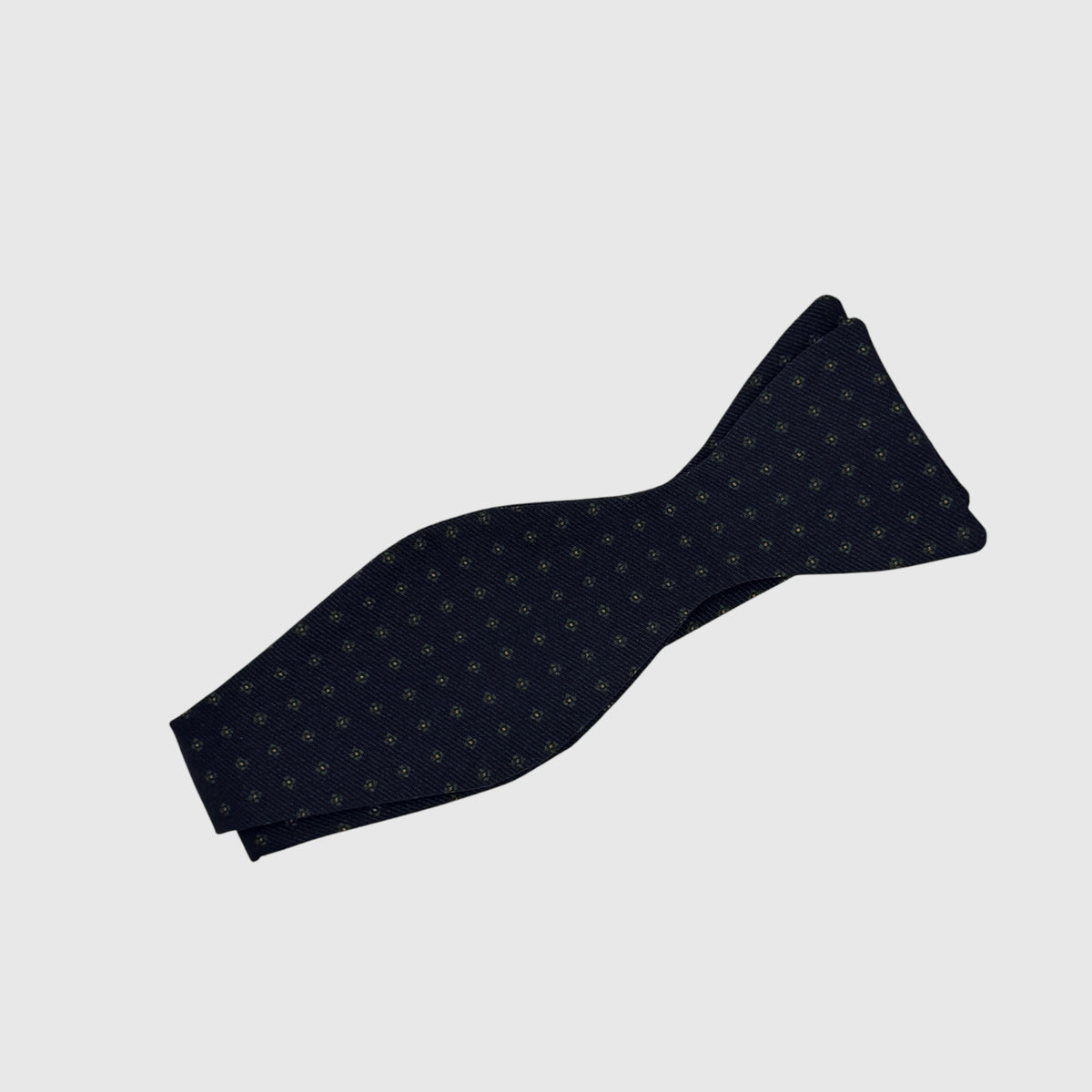 Navy self tie bow tie with a green medallion