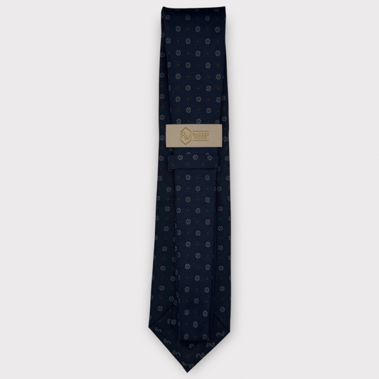 Classic silk necktie, printed in England, with a 9cm blade and 150cm length, laid flat against a plain background