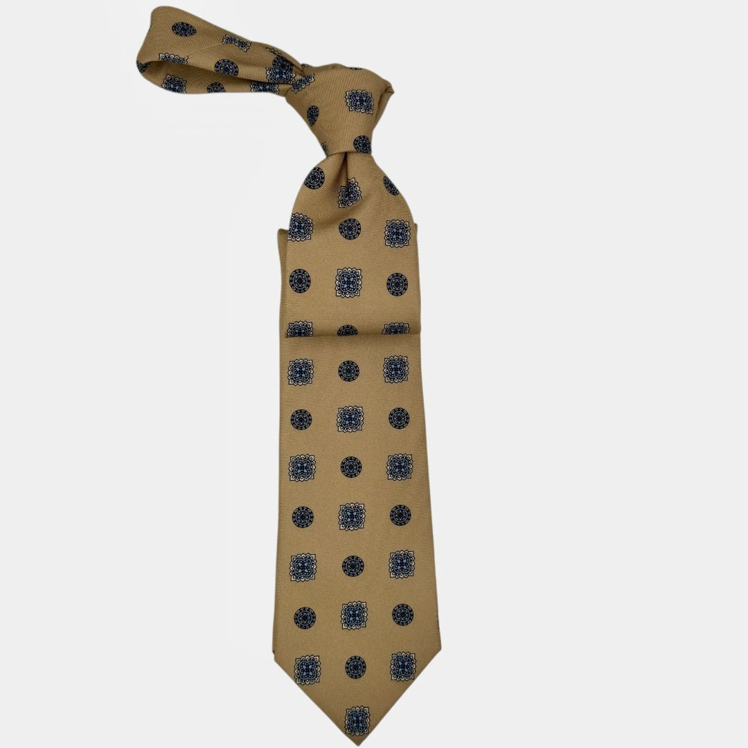 A camel coloured tie with light blue and navy large medallions.