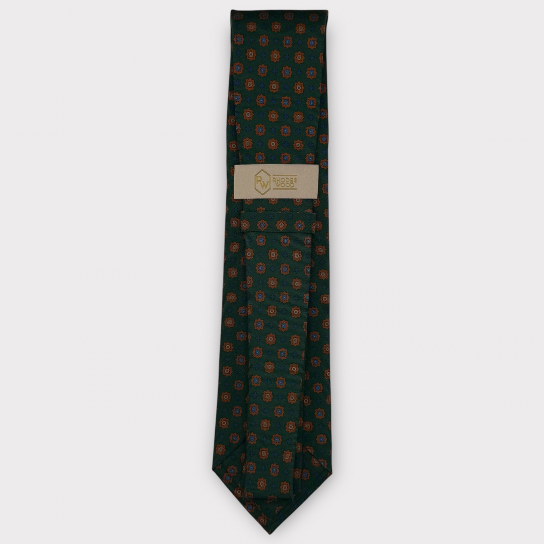 Classic silk necktie, printed in England, with a 9cm blade and 150cm length, laid flat against a plain background