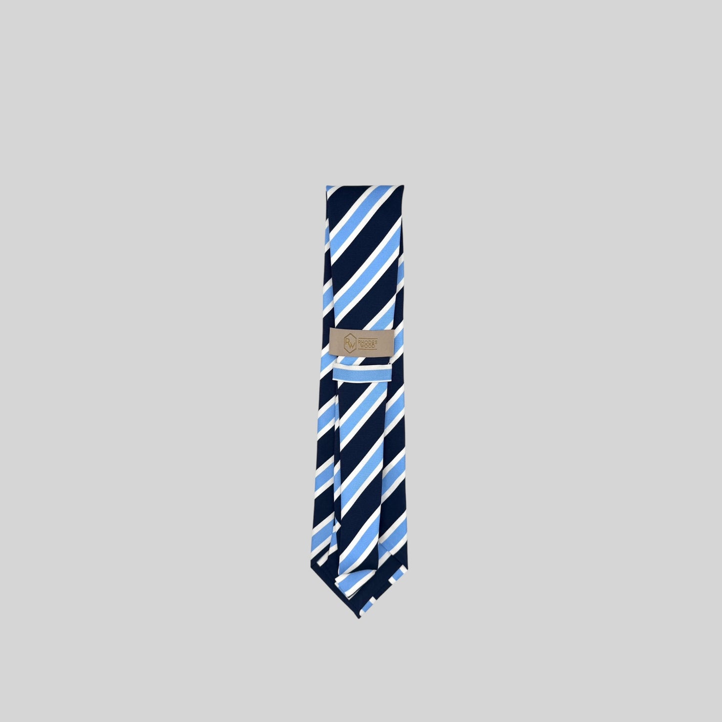 Men’s Rhodes Wood Tie, 100% Silk. The tie is navy with Light Blue and white diagonal striped. There is a Rhodes Wood Branded tie tab on the back of the tie to secure the blade of the tie. 