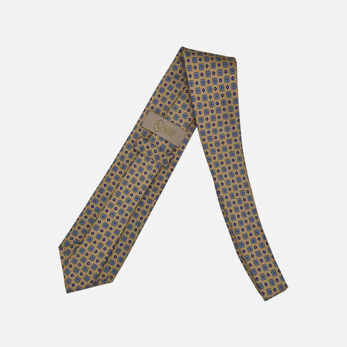 A camel base colour neck tie with navy medallions repeating. 