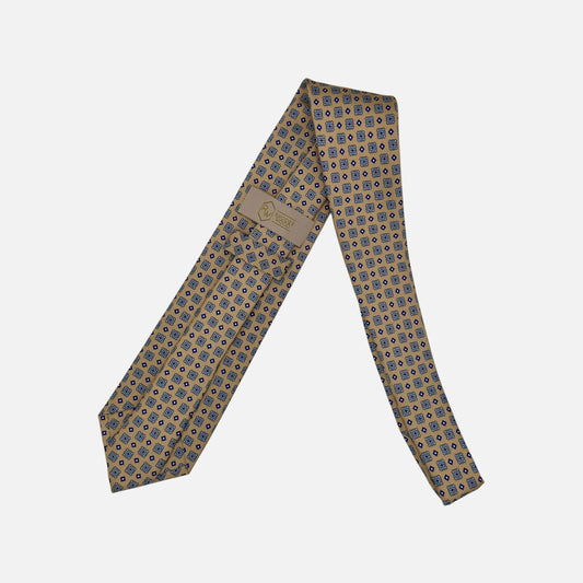 A camel base colour neck tie with navy medallions repeating. 