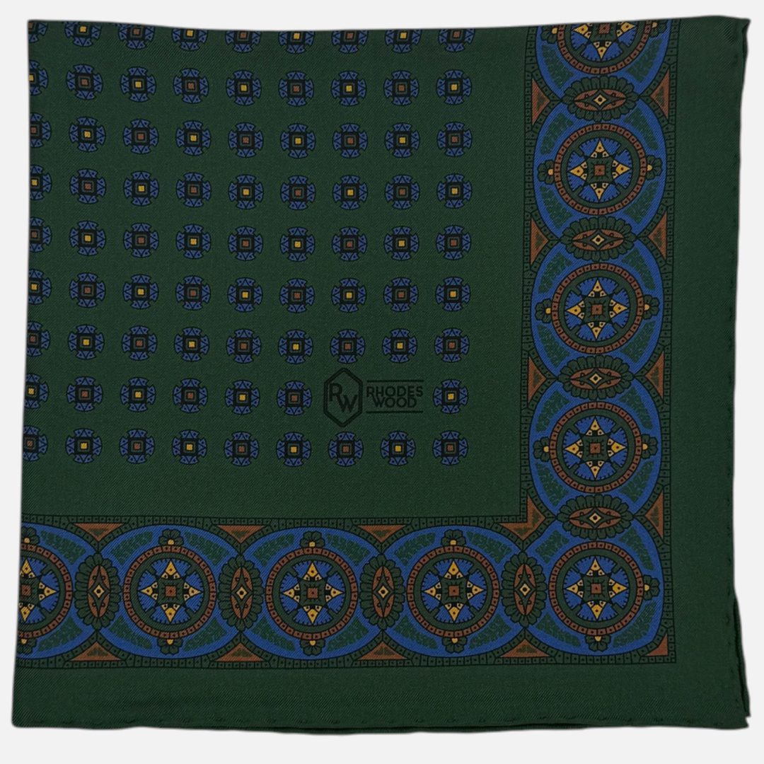 A green pocket square with repeating medallions across the silk. 