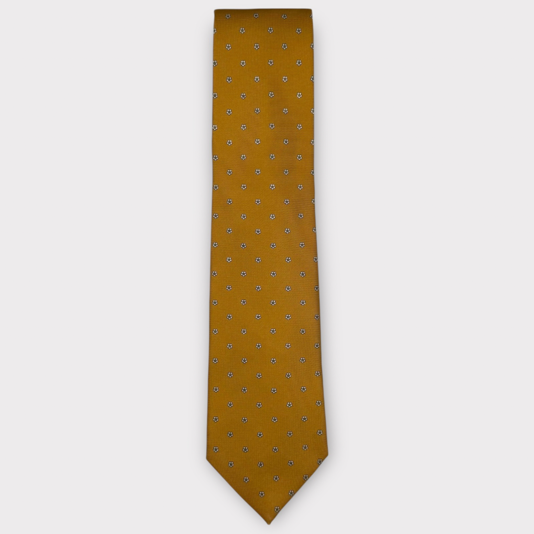 Classic silk necktie, printed in England, with a 9cm blade and 150cm length, laid flat against a plain background