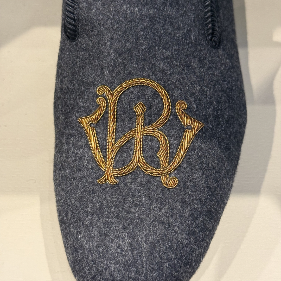 Embroidered initials on a dark gray fabric background