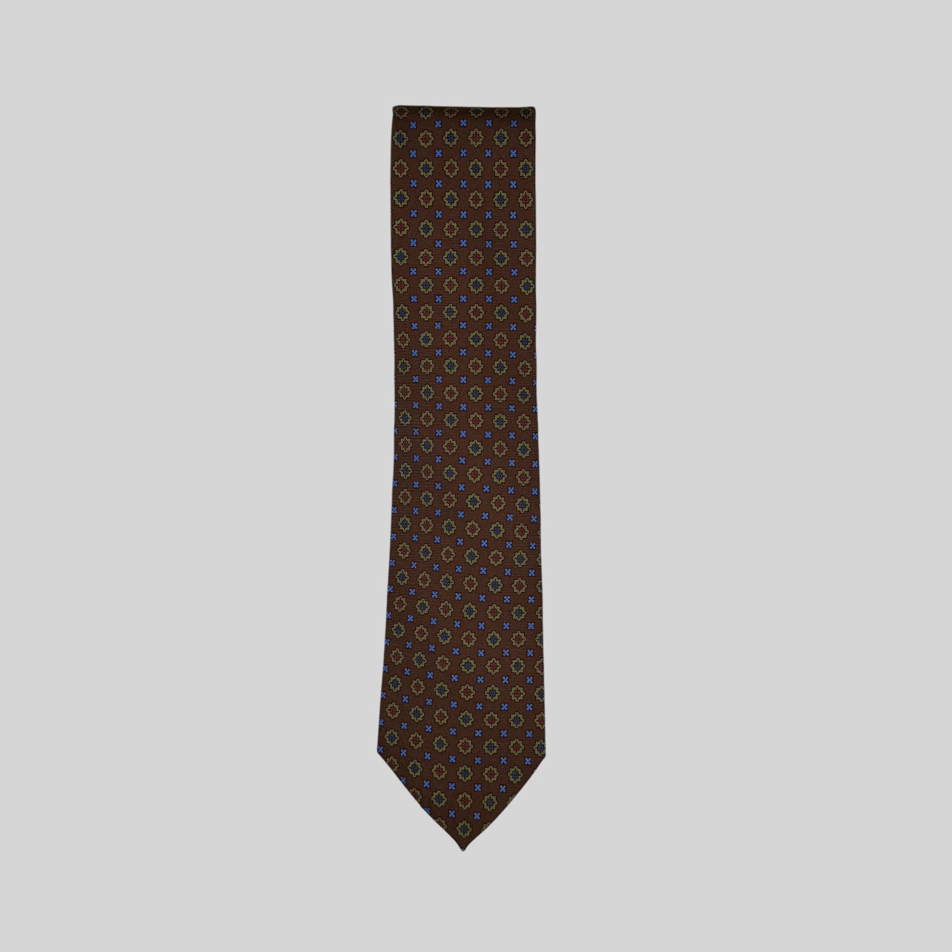 A Rhodes Wood tie in a brown base colour featuring a small medallion pattern in green, blue & red