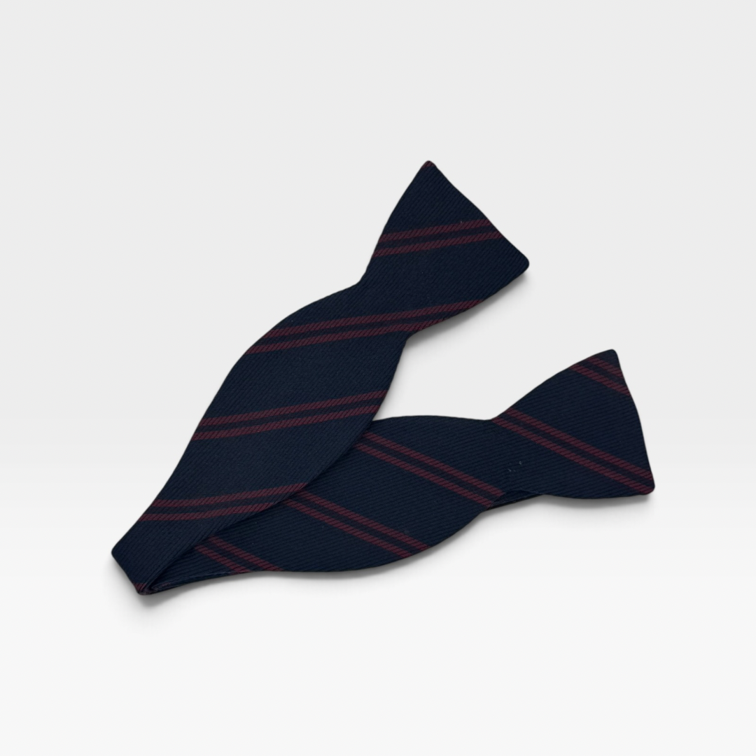 A self tie navy bow tie with a red stripe diagonal.