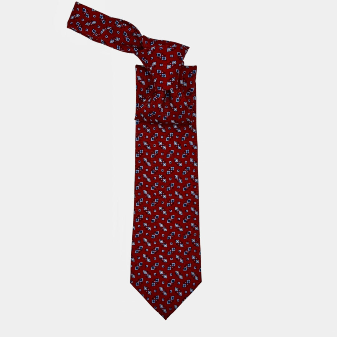 A classic red necktie with sky blue and navy geometric patterns.