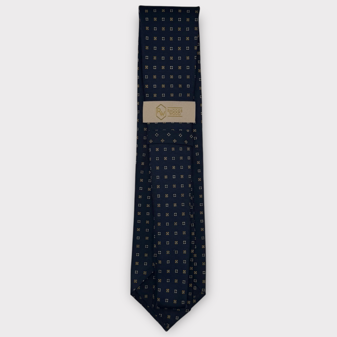 Classic silk necktie, printed in England, with a 9cm blade and 150cm length, laid flat against a plain background