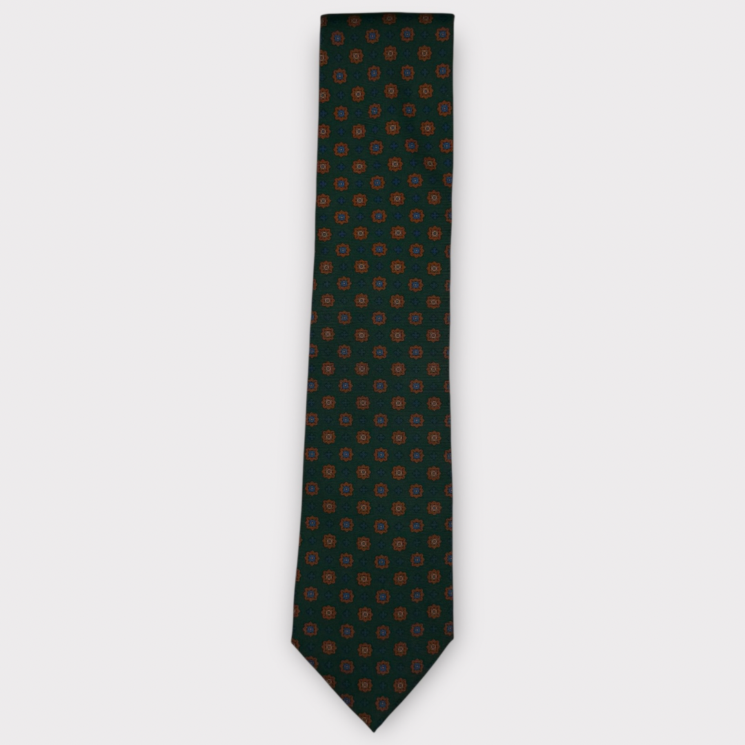 Classic silk necktie, printed in England, with a 9cm blade and 150cm length, laid flat against a plain background