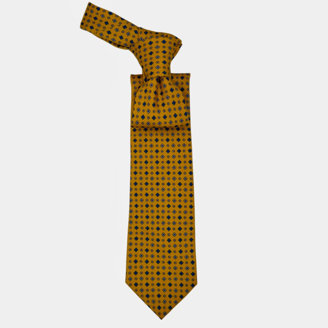A mustard colour necktie with sky blue yellow and blue medallions. 