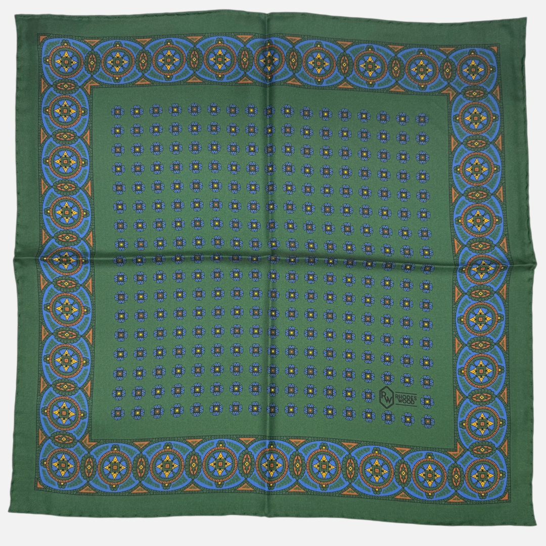 A green pocket square with repeating medallions across the silk. 