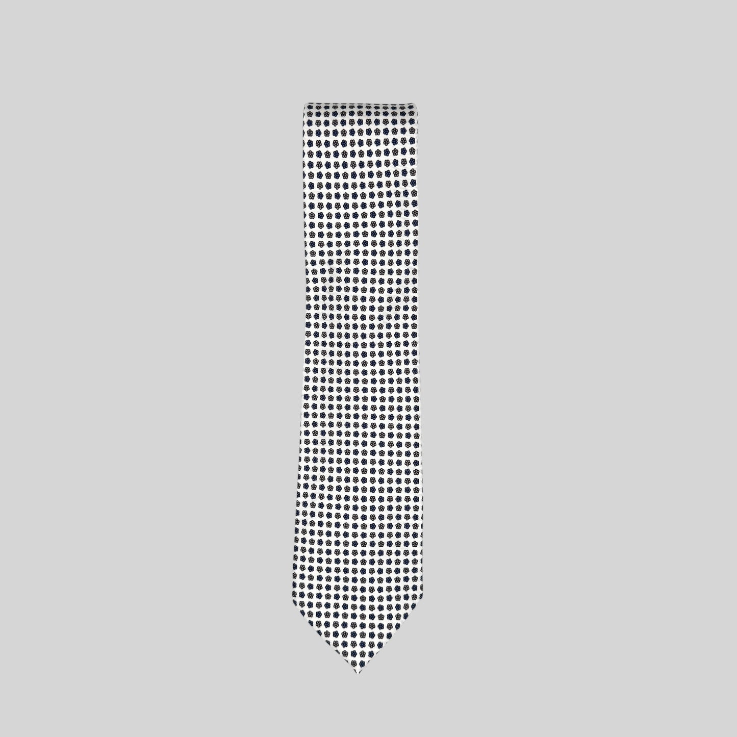 a white Rhodes Wood tie with a navy miniature floral print. 