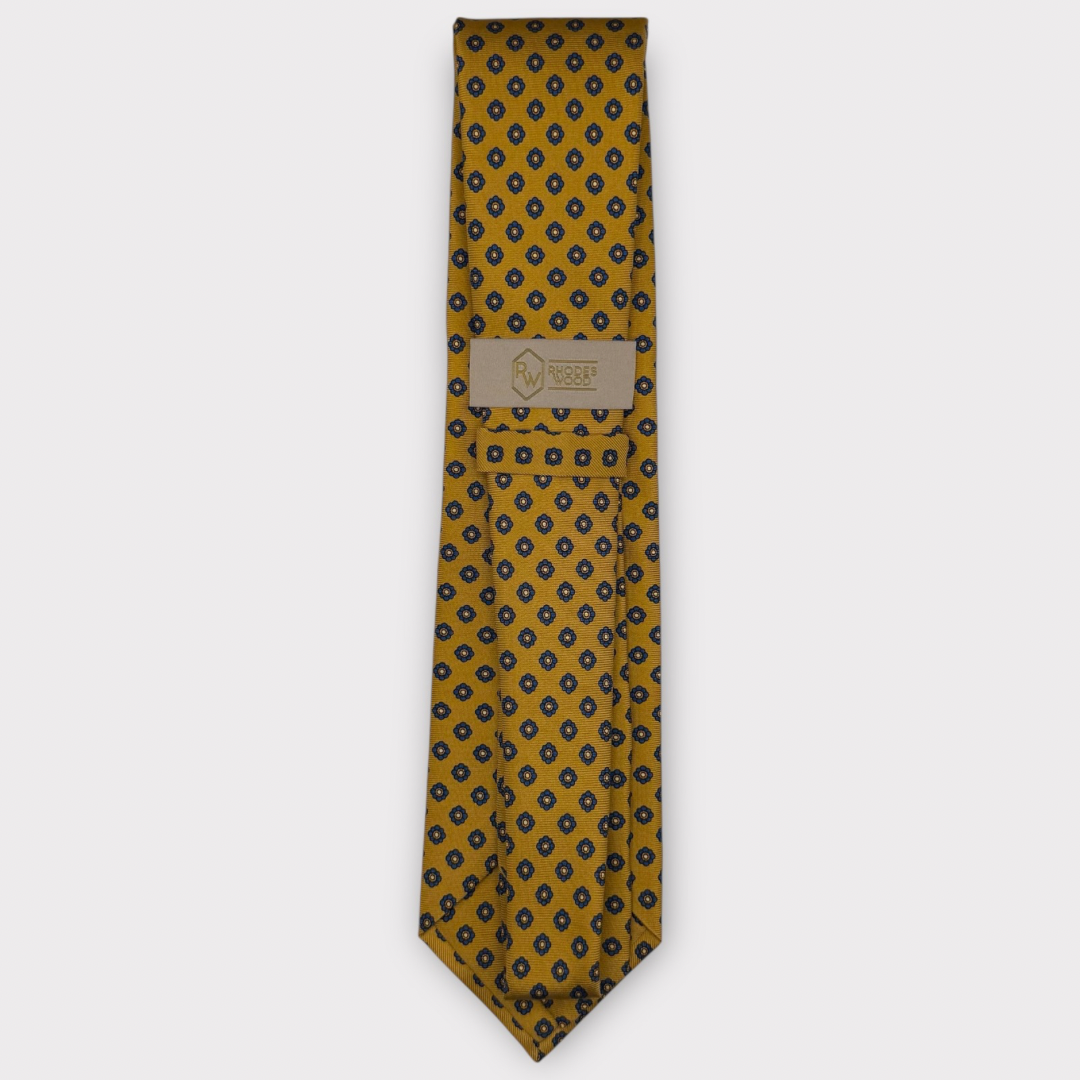 Classic silk necktie, printed in England, with a 9cm blade and 150cm length, laid flat against a plain background