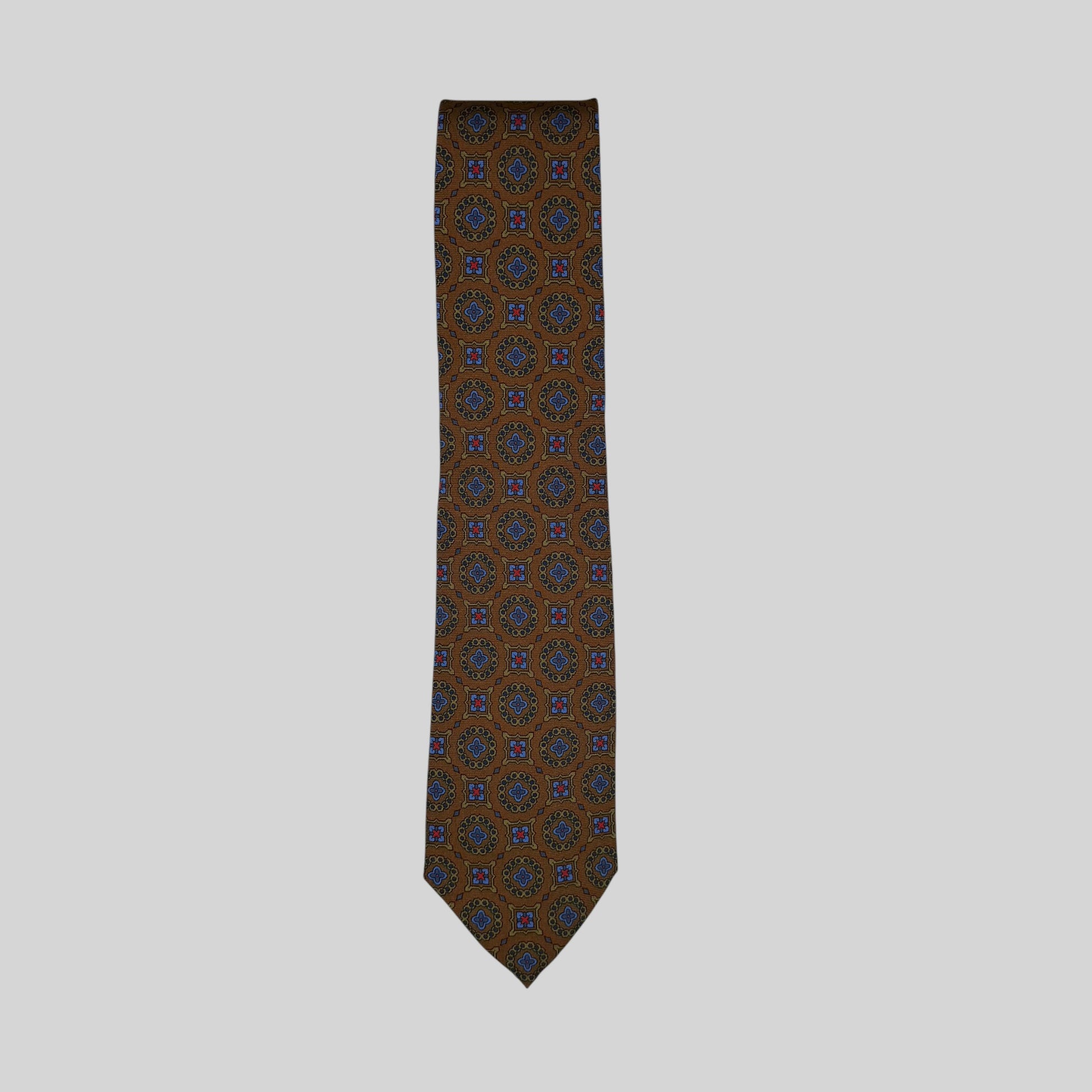 Rhodes Wood tie featuring a medallion design in  brown, blue, and gold,