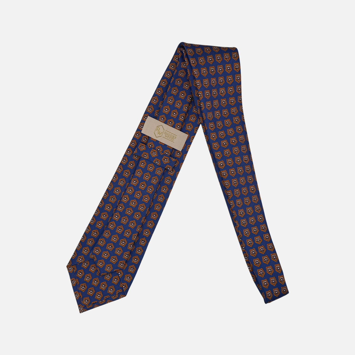A royal blue necktie with deep rust star medallions repeating across the silk.