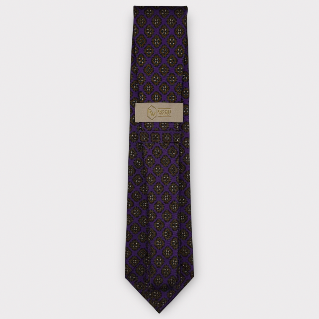 Classic silk necktie, printed in England, with a 9cm blade and 150cm length, laid flat against a plain background