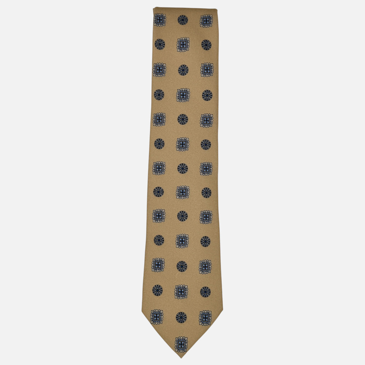 A camel coloured tie with light blue and navy large medallions.