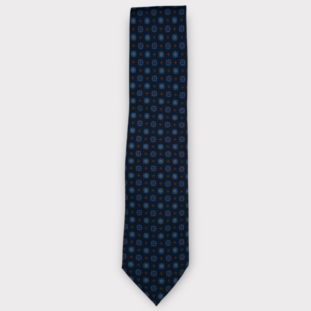 Classic silk necktie, printed in England, with a 9cm blade and 150cm length, laid flat against a plain background