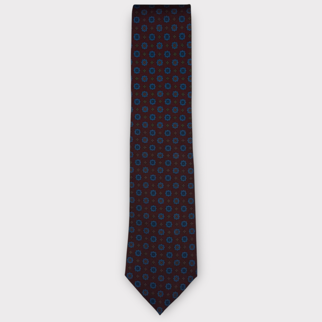Classic silk necktie, printed in England, with a 9cm blade and 150cm length, laid flat against a plain background