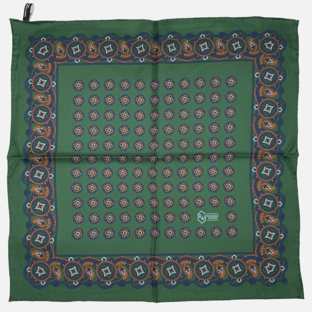 Green pocket square with blue and orange quatrefoils repeating across the silk.